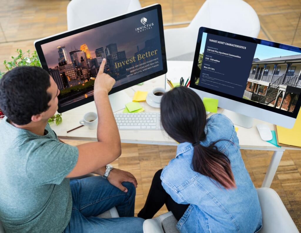 Two Professionals At A Desk Engaged In Work With Two Monitors